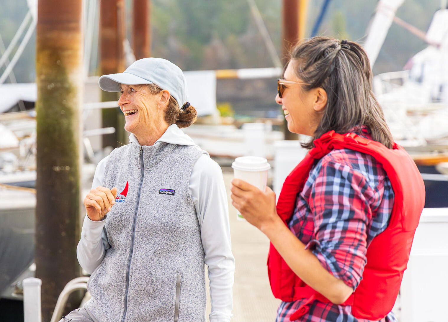 Annalise and a friend laughing on the docks. The vibe at Wild About Sailing is always positive, welcoming and fun!